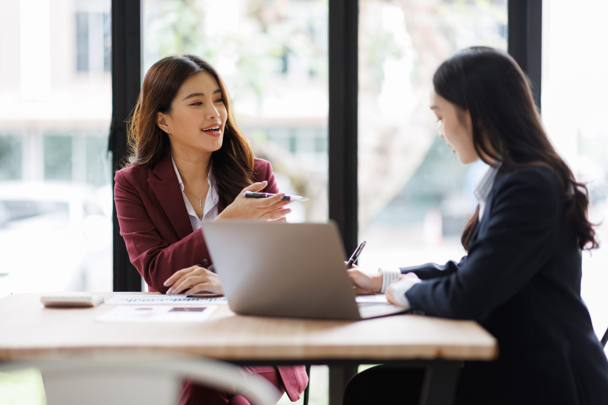 Two business professionals engage in a discussion at a modern office table