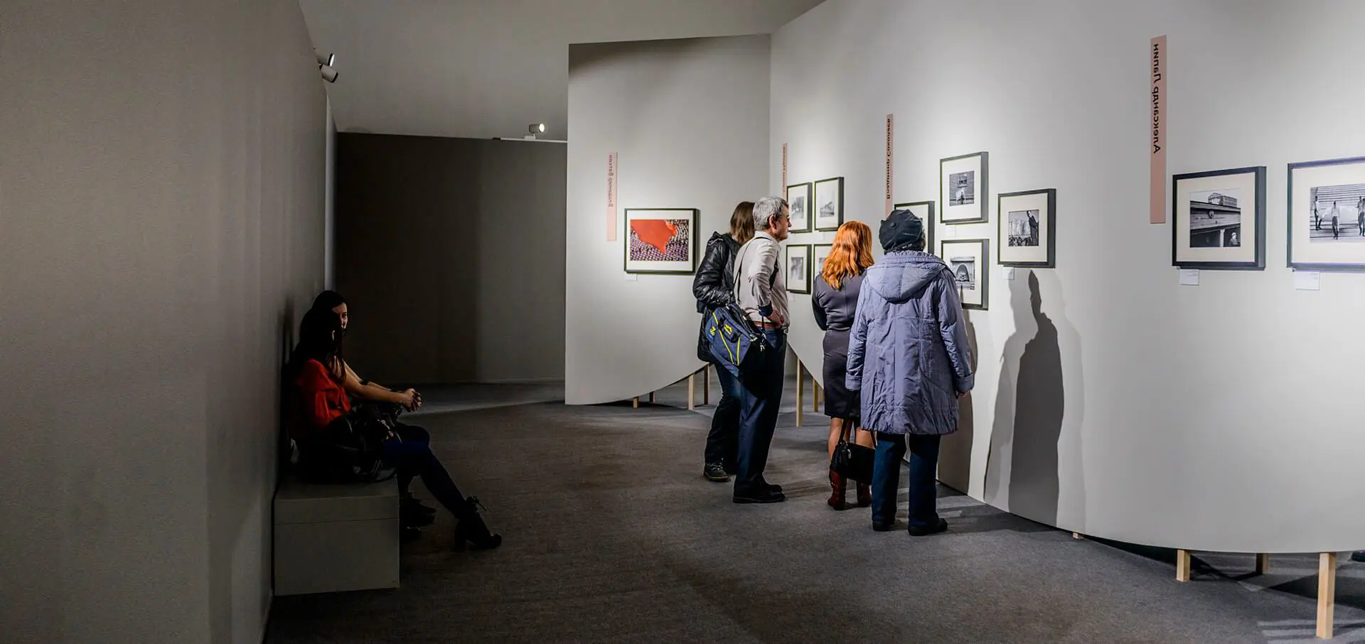 Visitors explore a photography exhibit in a gallery
