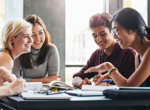 A group of diverse people gathered talking at a meeting table